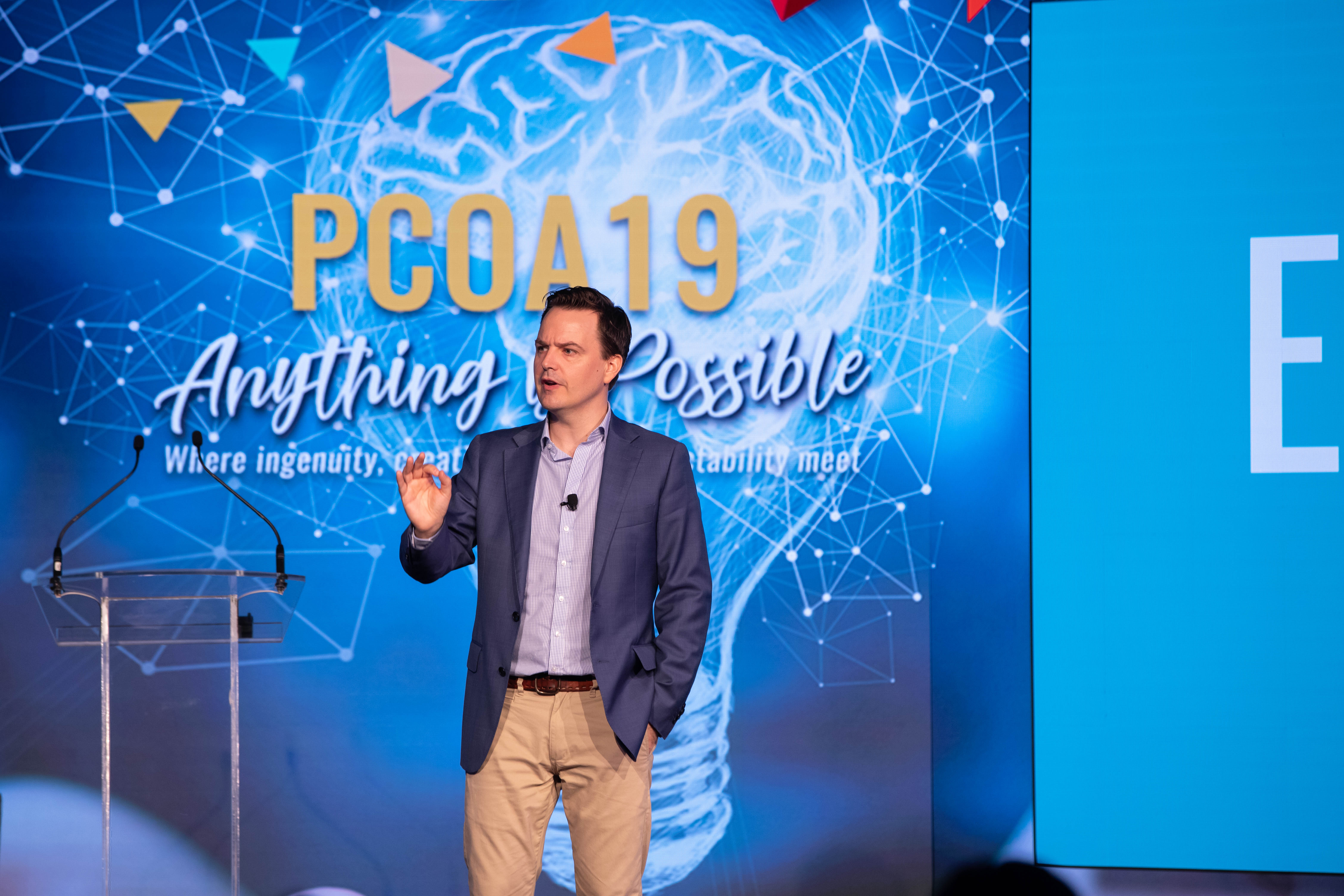Shaun presenting on stage at a conference